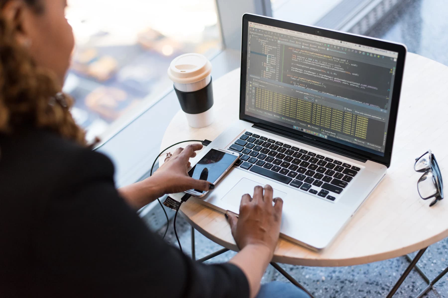 Développeuse noire travaillant sur du code depuis un ordinateur portable