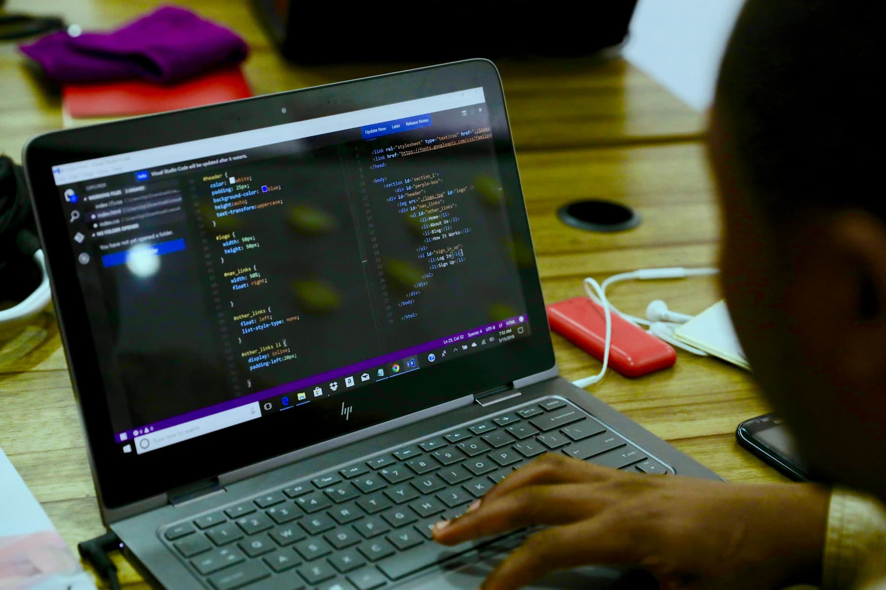 Développeur nigérian écrivant du code sur un ordinateur portable à Lagos